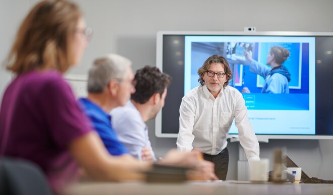Vier Menschen am Schreibtisch während eines Meetings im Büro