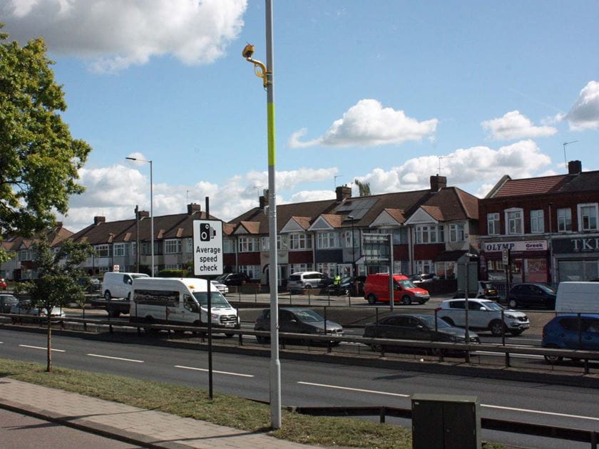 A stretch of the A10 road in North London with average speed cameras on a pole