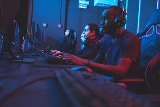 Video gamers in a bluish dark room